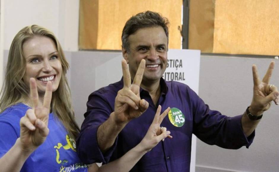 El candidato a la Presidencia Aécio Neves posa junto a su esposa Leticia Weber después de votar.