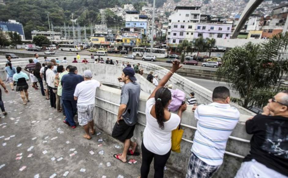 Un grupo de personas hacen cola frente a la favela de Rocinha en los colegios electorales de Brasil.
