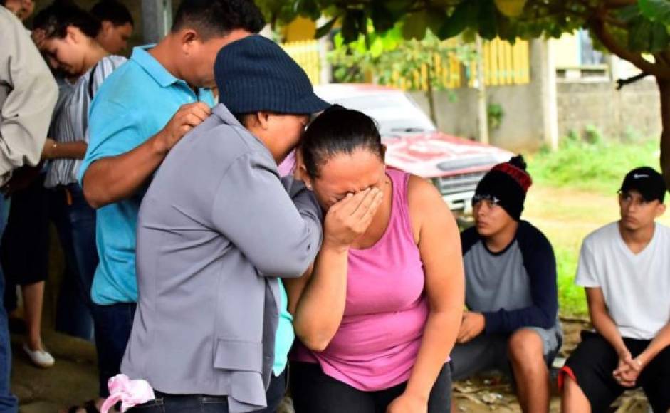 Dos mujeres se consuelan tras conocer que su esposo e hijo falleció en la reyerta suscitada en la cárcel de Tela.