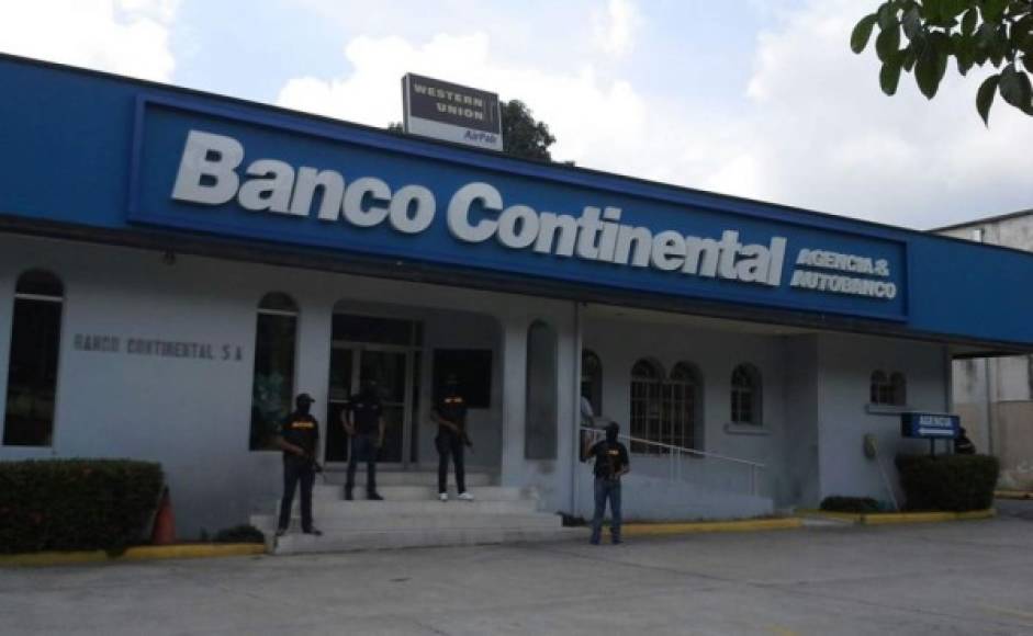 Agentes de la Dirección de Lucha Contra el Narcotráfico (DLCN) resguardan la agencia bancaria asegurada en el bulevar Morazán en San Pedro Sula.