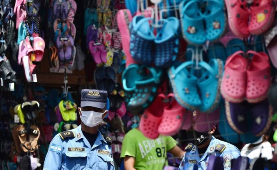 Un policía usa una máscara facial durante la pandemia COVID-19 en un mercado callejero. Foto AFP