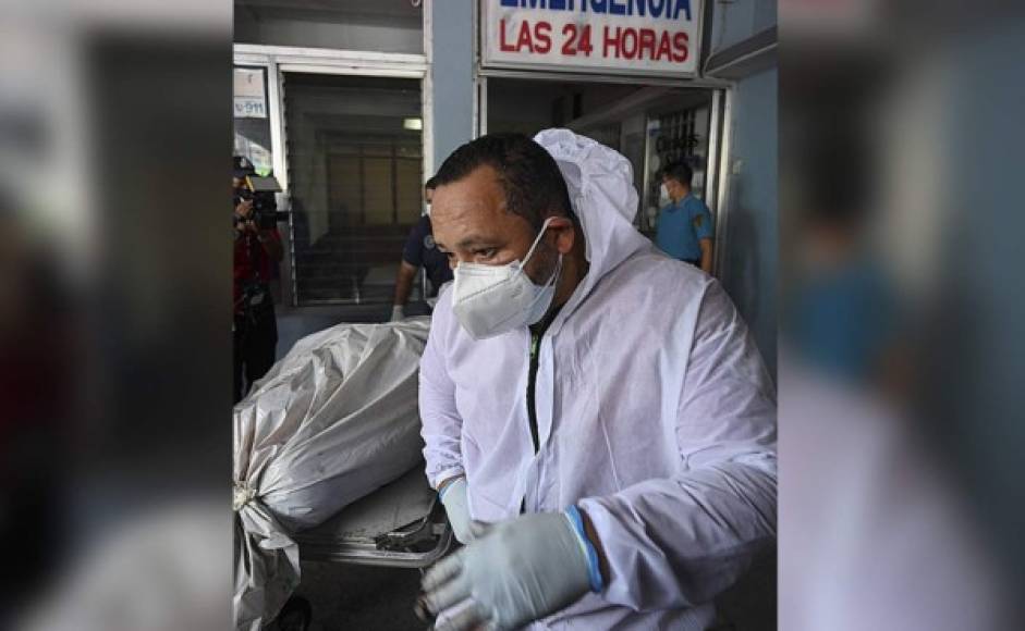 Trabajadores llevan una bolsa plástica con los restos del empresario, quien estaba en una unidad de cuidados intensivos por covid-19. Foto AFP