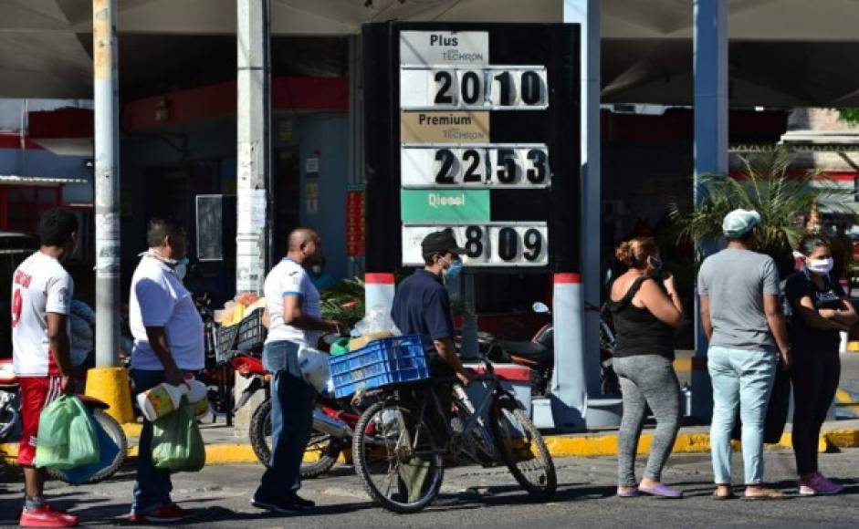 La gente hace cola para comprar aceite de queroseno en una estación de combustible en Tegucigalpa. Foto AFP