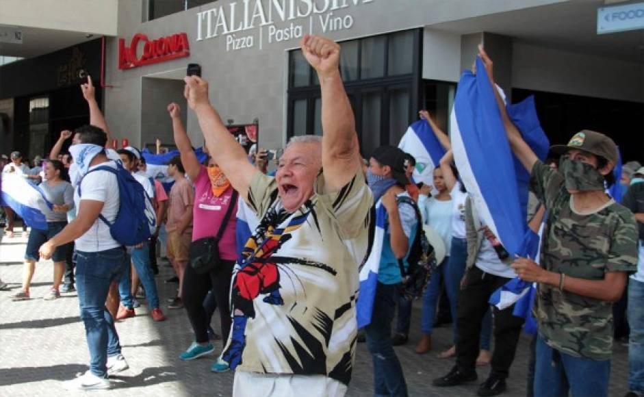 <br/>Los manifestantes de la oposición gritan consignas desde un centro comercial donde se reunieron después de que la policía antidisturbios nicaragüense les impidiera demostrar que exigen al gobierno la liberación de los arrestados por participar en protestas antigubernamentales, en los alrededores de la rotonda de Centroamérica en Managua. Foto AFP.