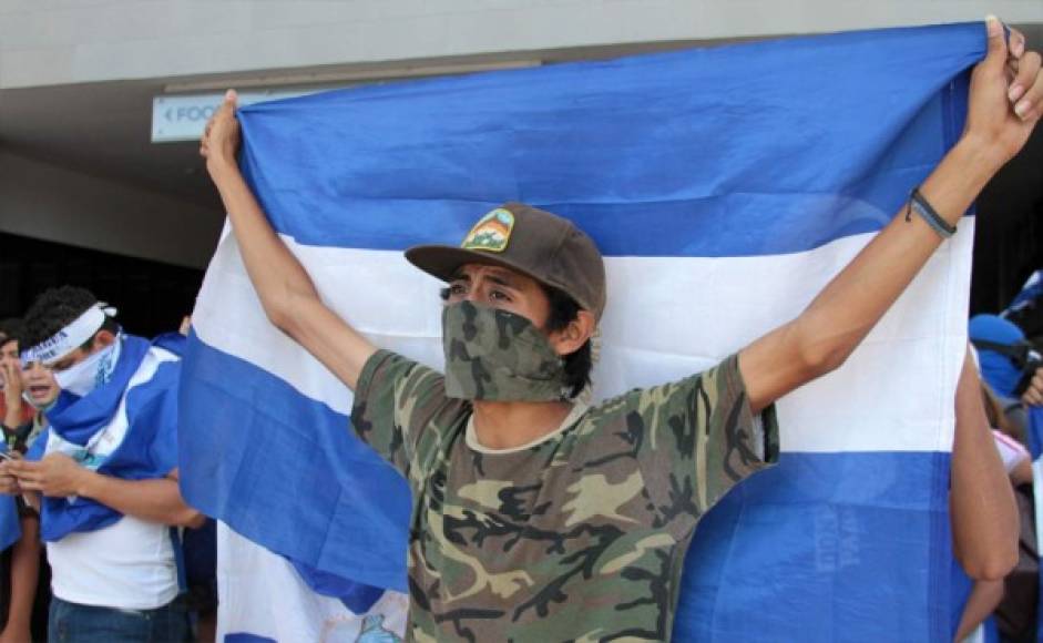 <br/>Un manifestante de la oposición sostiene una bandera nicaragüense en un centro comercial donde muchos se reunieron después de que la policía antidisturbios de Nicaragua les impidiera manifestarse para exigir al gobierno la liberación de los arrestados por participar en protestas antigubernamentales, en los alrededores de la rotonda de Centroamérica. Foto AFP.