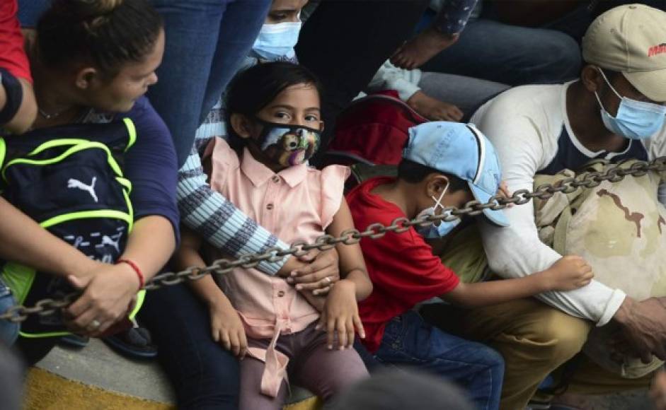 Los migrantes hondureños permanecen en la frontera antes de romper una cerca policial y entrar a Guatemala desde Corinto. Foto AFP