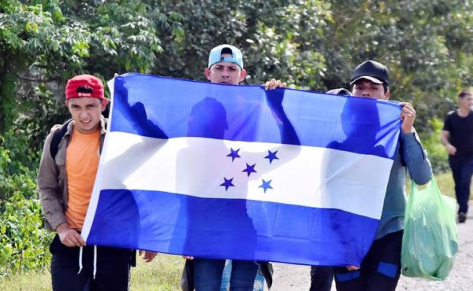 Los migrantes caminaban por la carretera asfaltada al borde del mar Caribe mientras policías y militares los seguían de cerca en vehículos y retenes.