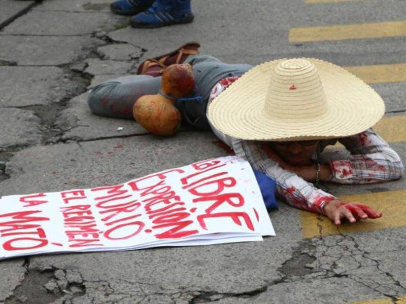 Este hombre se lanzó al suelo con una pancarta donde se podía leer. 'La libre expresión murió'.