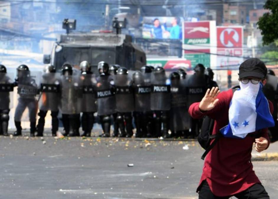 Policías lanzaron bombas lacrimógenas a unos 1,000 manifestantes de la oposición mientras marchaban paralelamente al desfile organizado por el gobierno en el centro de Tegucigalpa.