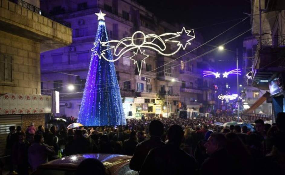 Los sirios asisten a la iluminación de un árbol de navidad en la Plaza Al-Azizzieh en Alepo, noroeste de Siria.