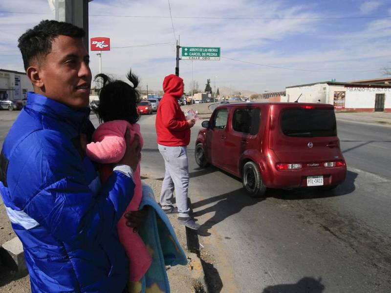 Migrante en México cargando en brazos a una niña pequeña | Fotografía de archivo
