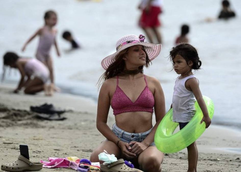 Una guapa mujer y su pequeña hija disfrutaron del sol y la playa en Puerto Cortés. (AFP)