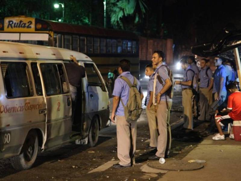 Estudiantes de la jornada nocturna esperan abordar un rapidito luego de clases en las afueras del Reyes. Los asaltos al transporte han disminuido en ese sector.