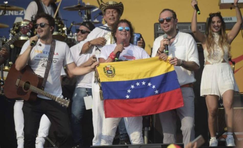 Carlos Vives sostiene una bandera de Venezuela.