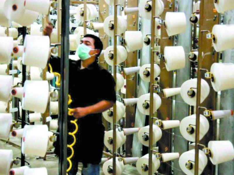 Un trabajador supervisa la producción de hilos en una fábrica de la zona norte del país.