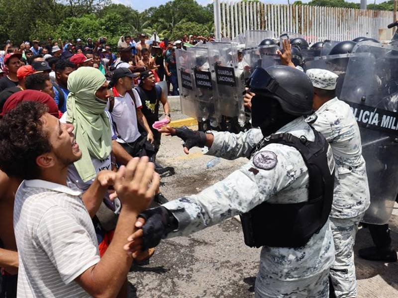 Personal de la Guardia Nacional (GN) impiden el paso este miércoles, a migrantes a las oficinas del Instituto Nacional de Migración (INM) en el municipio de Huixtla, en Chiapas (México). EFE