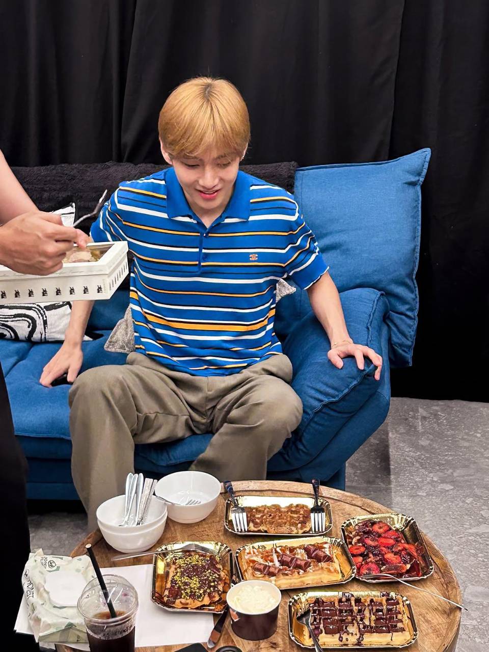 En la imagen se aprecia a V disponiéndose a comer durante una pausa en la gira musical del grupo. Los Army ya pueden reservar en línea los libros BTS Lyrics Inside y BTS Recipe Book.