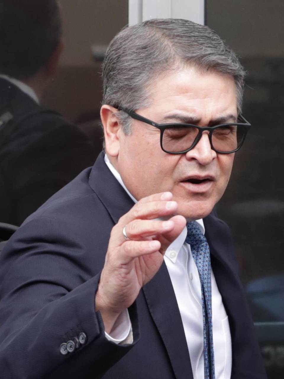 El expresidente de Honduras Juan Orlando Hernández saluda a simpatizantes a su llegada a la reanudación de la audiencia.
