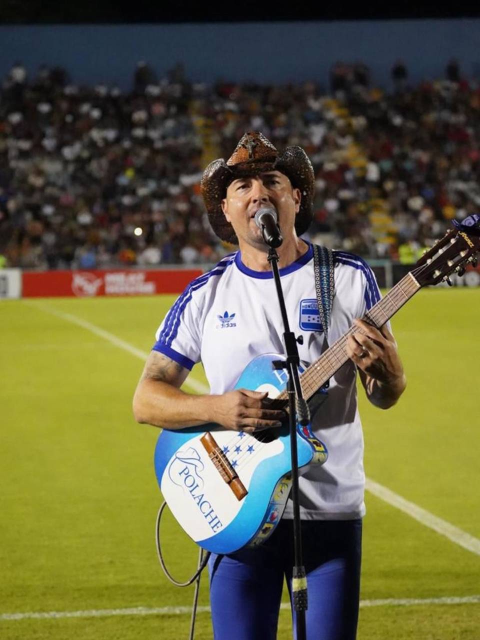 Polache con guitarra en mano cantando para el público ceibeño.