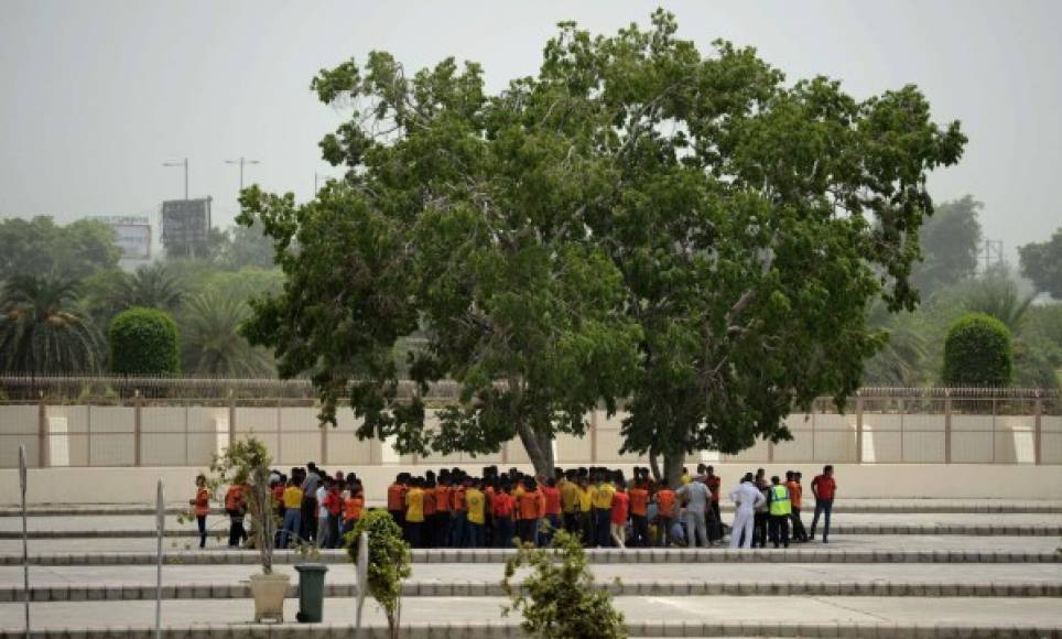 Decenas de turistas buscan refrescarse en la sombra de un árbol en Nueva Delhi.