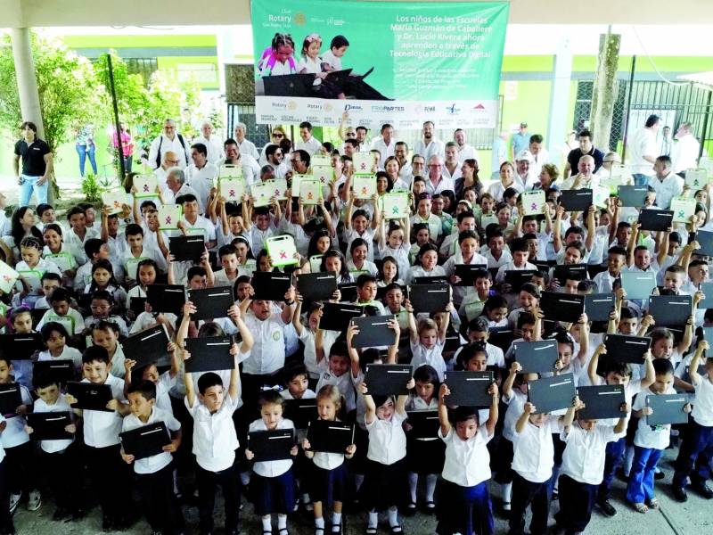 Con una sonrisa recibieron los pequeños estudiantes la computadora entregada por las autoridades. Diferentes autoridades encabezaron la mesa principal durante el acto de entrega. Los niños hicieron presentaciones artísticas. Fotos: Melvin Cubas.