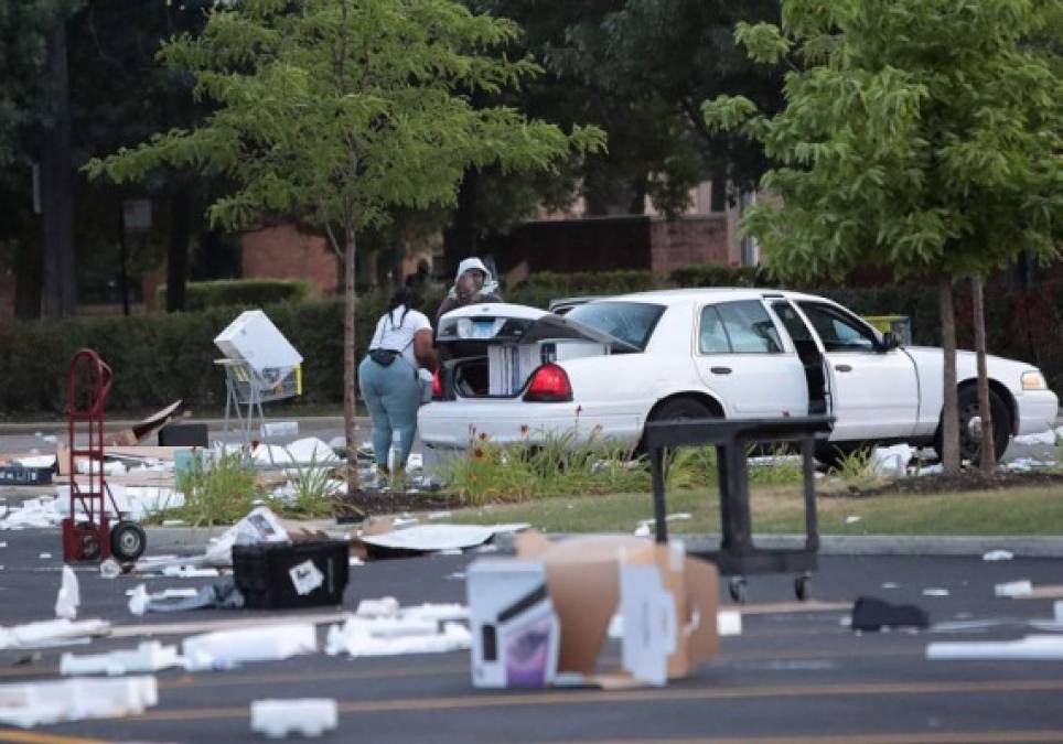 CHICAGO, ILLINOIS - AUGUST 10: People load merchandise into a car near a looted Best Buy store after parts of the city had widespread looting and vandalism, on August 10, 2020 in Chicago, Illinois. Police made several arrests during the night of unrest and recovered at least one firearm. Scott Olson/Getty Images/AFP<br/><br/>== FOR NEWSPAPERS, INTERNET, TELCOS & TELEVISION USE ONLY ==<br/><br/>