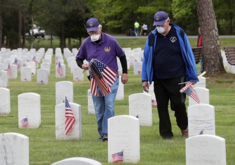 Voluntarios estadounidenses ayudaron a colocar las banderas frente a las tumbas de los caídos en combate en cementerios militares de todo el país.