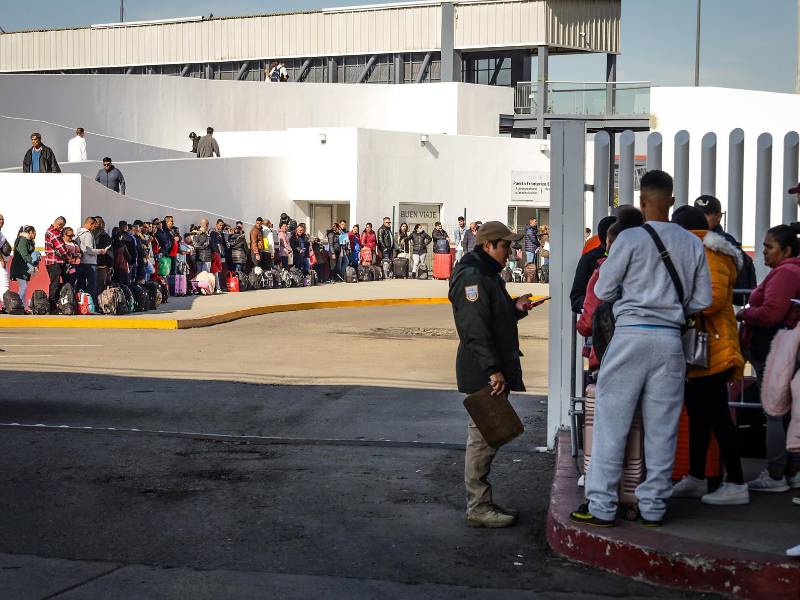 Migrantes hacen fila para solicitar un proceso de asilo en Estados Unidos, el 25 de enero de 2024 en el paso fronterizo del Chaparral en Baja California (México).