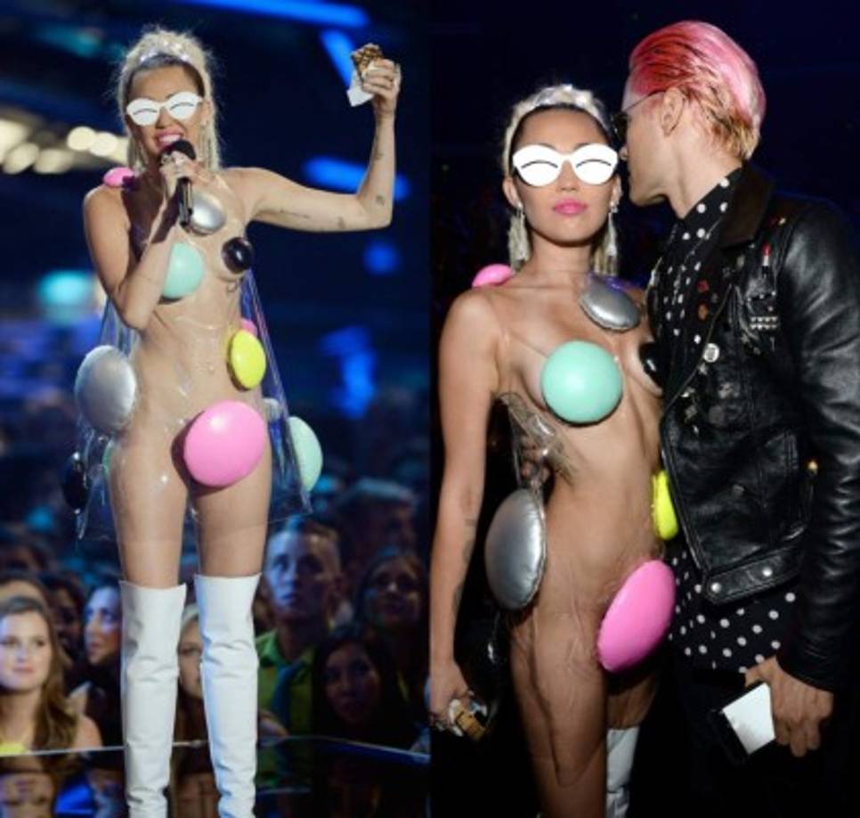 Con un vestido de plástico transparente decorado con puntos de colores en las zonas 'clave', botas altas de charol blancas y una maxi coleta de rastas Miley sorprendió al público una vez más.
