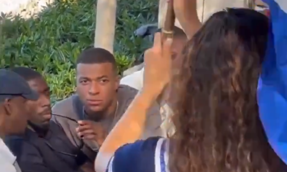 Mbappé estaba platicando con Dembélé cuando de repente apareció esta misteriosa joven que rápidamente llamó la atención del atacante. No podía dejar de verla en tan solo un segundo.