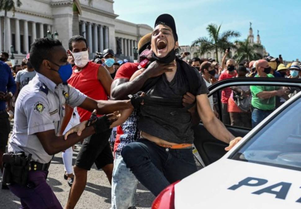 TOPSHOT - A man is arrested during a demonstration against the government of Cuban President Miguel Diaz-Canel in Havana, on July 11, 2021. - Thousands of Cubans took part in rare protests Sunday against the communist government, marching through a town chanting 'Down with the dictatorship' and 'We want liberty.' (Photo by YAMIL LAGE / AFP)