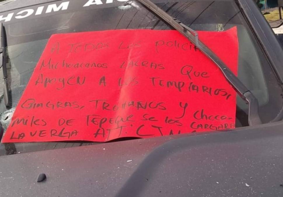 'A todos los policías michoacanos lacras que apoyen a los templarios...se los cargará la v..' se leen en uno carteles colgados en las patrullas.