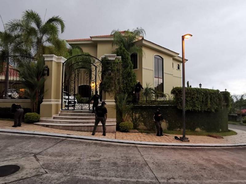 Agentes de la Dirección de Lucha Contra el Narcotráfico en las afueras de una vivienda.