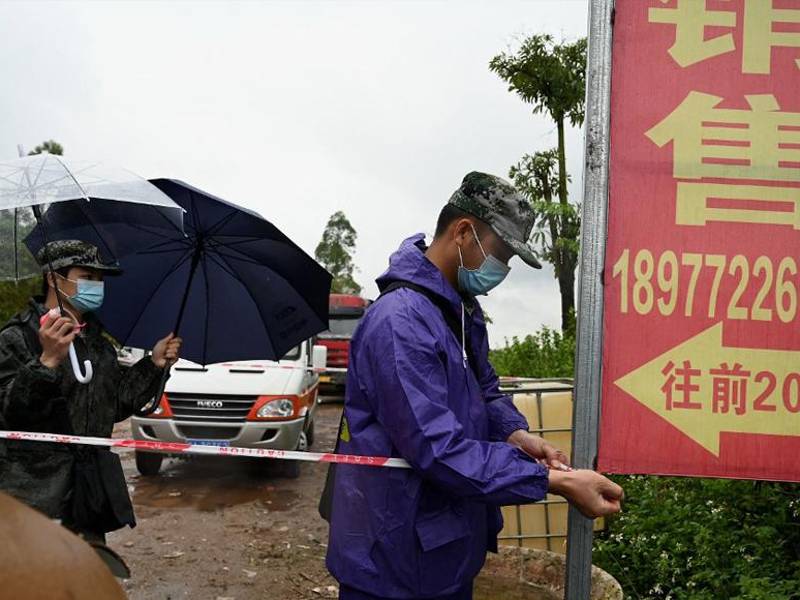 El personal de seguridad usa cinta perimetral para acordonar la entrada a la aldea de Lv que conduce al lugar del accidente del vuelo MU5375 de China Eastern en Wuzhou.