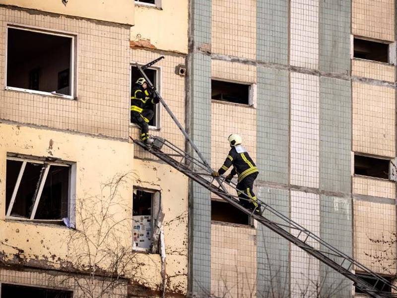 Los bomberos realizan operaciones en un edificio que fue alcanzado por los escombros de un cohete derribado.