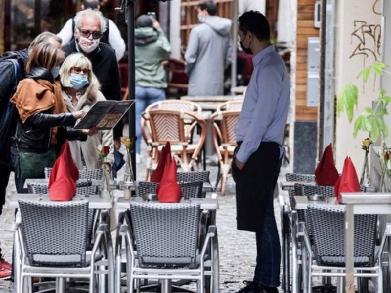 Un camarero espera a los clientes en una terraza en Bruselas mientras el gobierno de Bélgica alivió las restricciones impuestas. Foto AFP