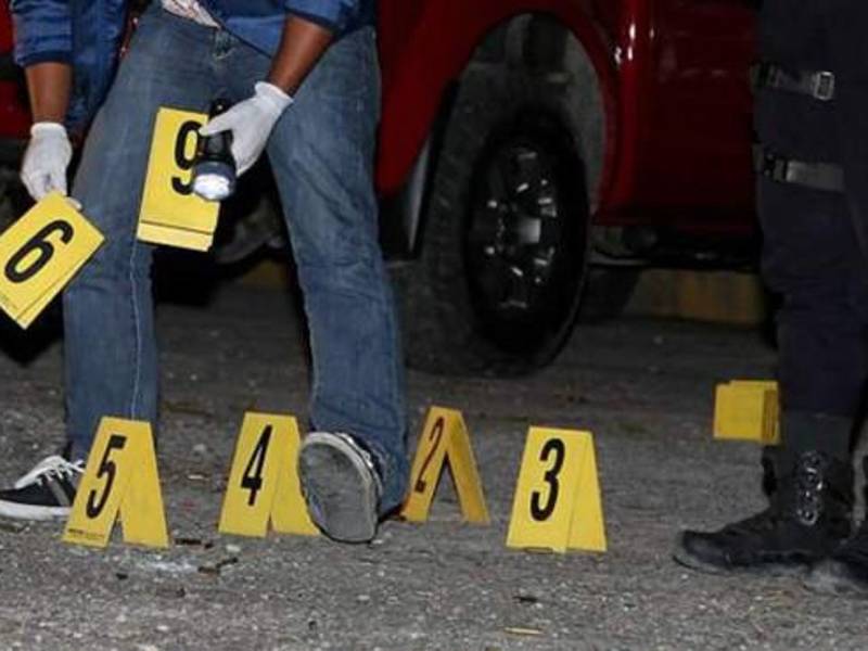 Policías inspeccionan una escena del crimen | Fotografía de archivo