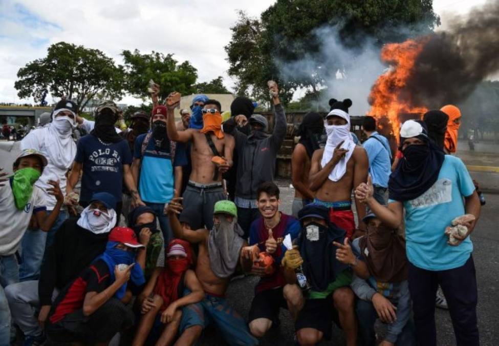 Venezuelan opposition demonstrators chant slogans during a protest against the government of President Nicolas Maduro on the anniversary of the 1958 uprising that overthrew the military dictatorship, in Caracas on January 23, 2019. - Venezuela's National Assembly head Juan Guaido declared himself the country's 'acting president' on Wednesday during a mass opposition rally against leader Nicolas Maduro. (Photo by YURI CORTEZ / AFP)