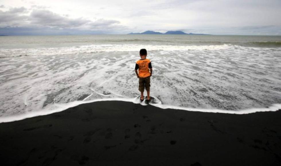 Un niño camina por la orilla en la playa Syiah en Indonesia durante el décimo aniversario del tsunami.
