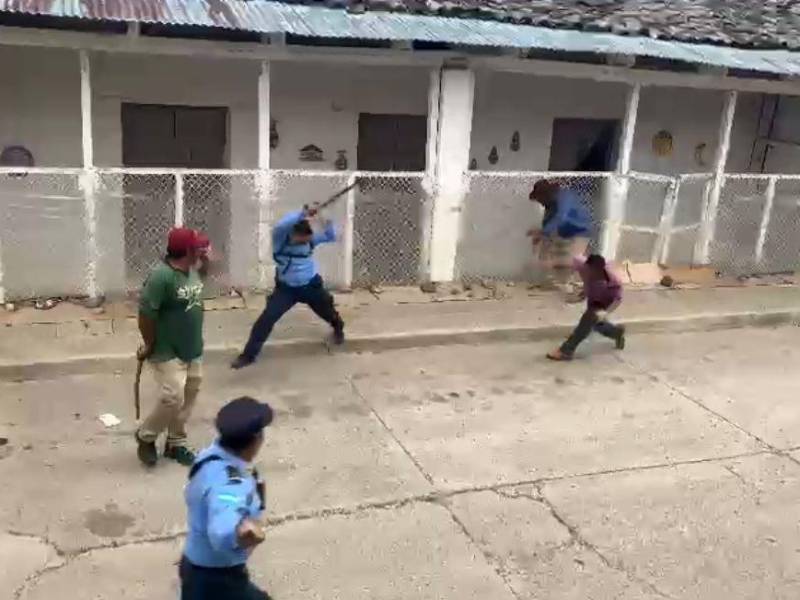 Imagen muestra el momento en que uno de los agresores lanza una piedra sobre la humanidad del agente de la Policía Nacional, en La Paz (Honduras).