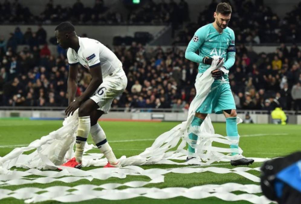 Hugo Lloris y el colombiano Davinson Sánchez trataron de retirar el papel que tiraron los aficionados del RB Leipzig. Foto AFP