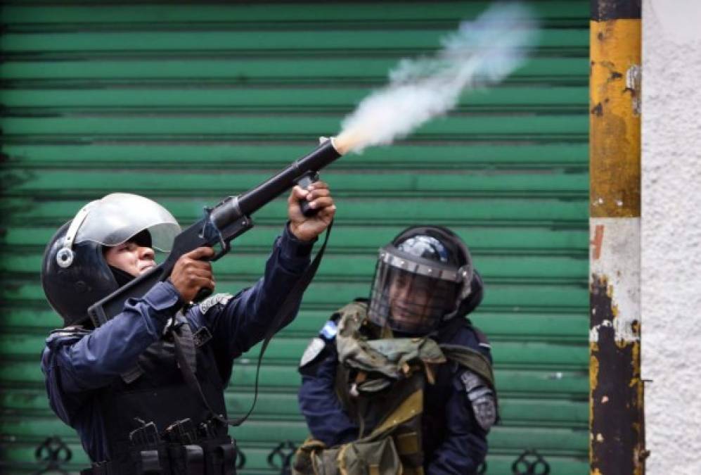 Un policía dispara un lanza morteros para tratar de dispersar a los manifestantes, quienes tiraron piedras a los uniformados.