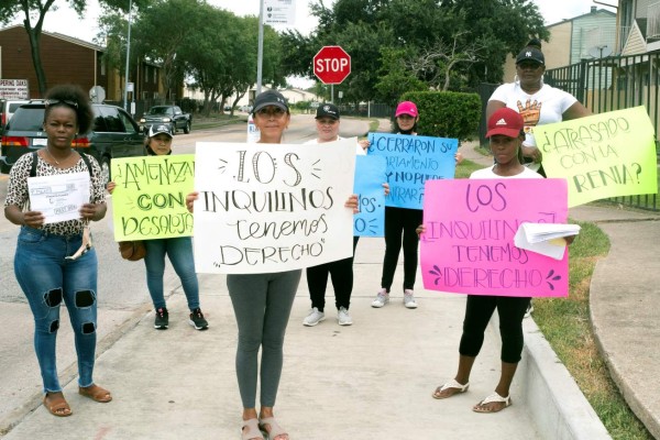 Unas voluntarias de la organización comunitaria Mujeres Trabajadoras Inmigrantes sostienen carteles durante un recorrido para ofrecer información sobre los derechos de los inquilinos en un barrio de alta población latina en el suroeste de Houston, Texas. EFE/Alicia L. Pérez
