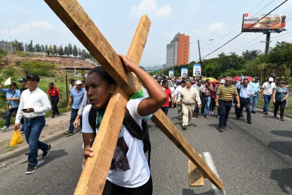 Members of teacher unions and the Honduran Medical Association demand the resignation of Honduran President Juan Orlando Hernandez and demonstrate against two privatization decrees which critics say will lead to mass layoffs, in Tegucigalpa, on May 14, 2019. - The Education and Health sectors are demanding the Congress to derogate the decrees. (Photo by Orlando SIERRA / AFP)