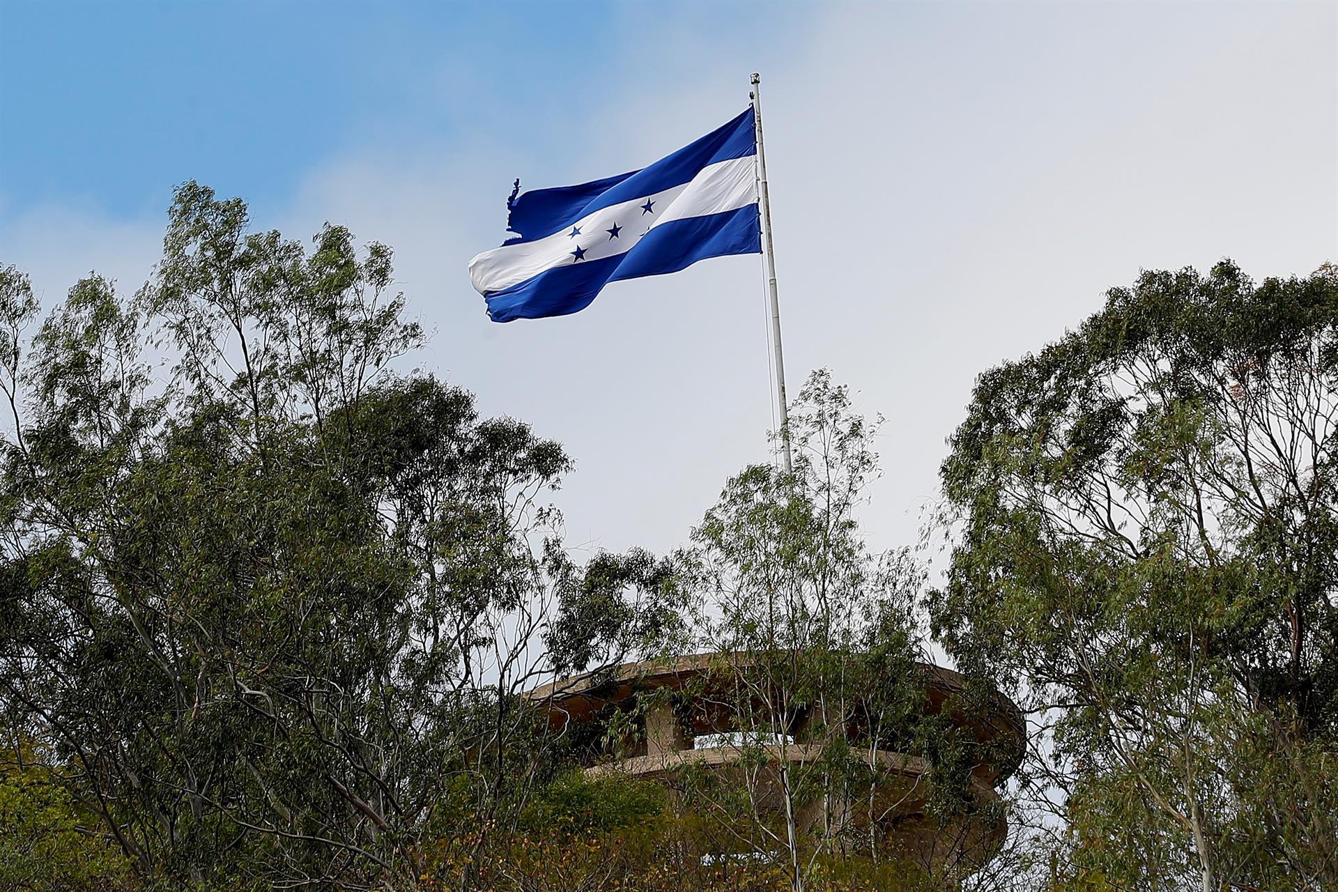 En un cerro capitalino se erige una bandera azul profundo.