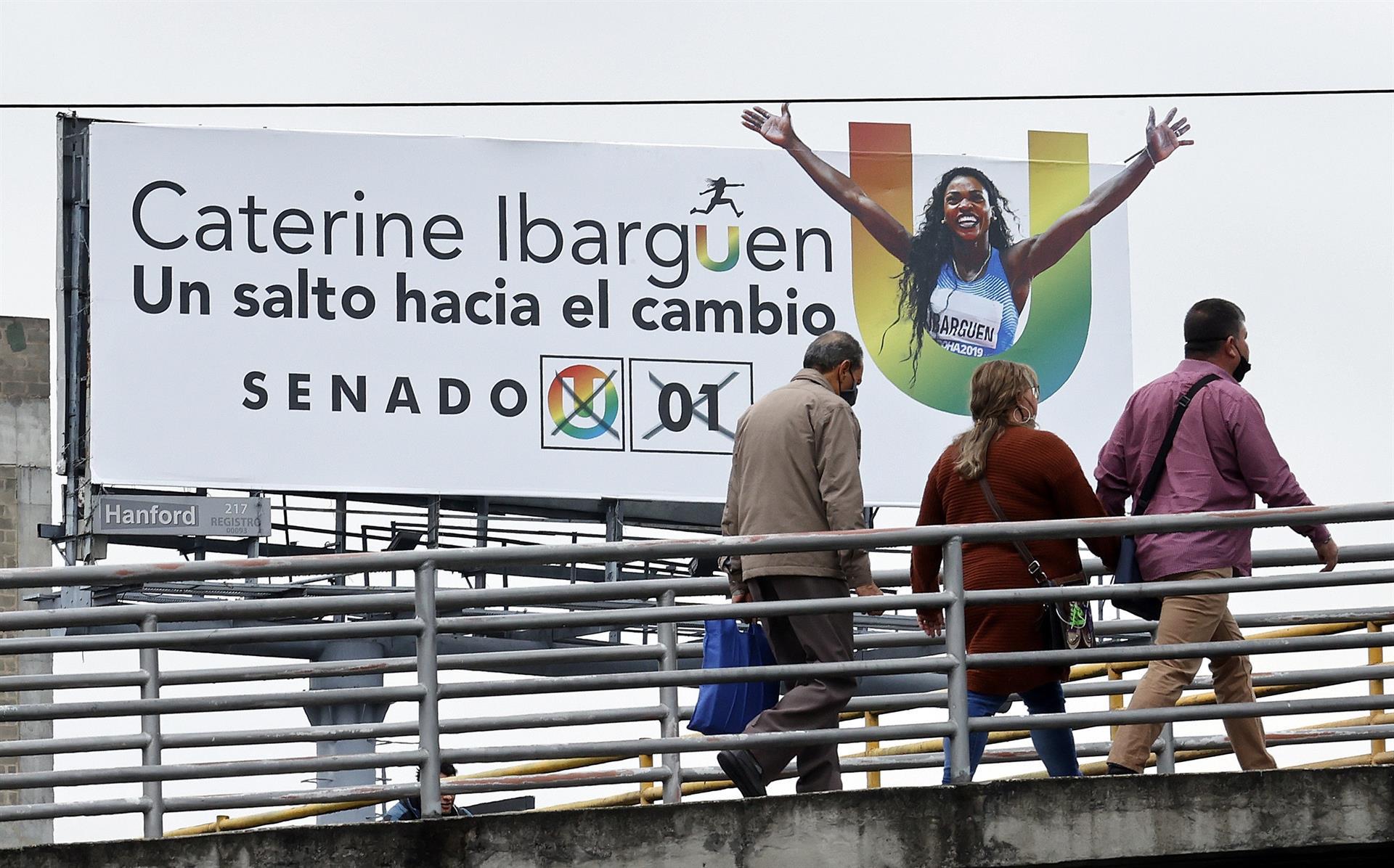 Peatones pasan junto a una valla electoral ayer miércoles en Bogotá (Colombia). A dos meses de las elecciones legislativas del 13 de marzo.