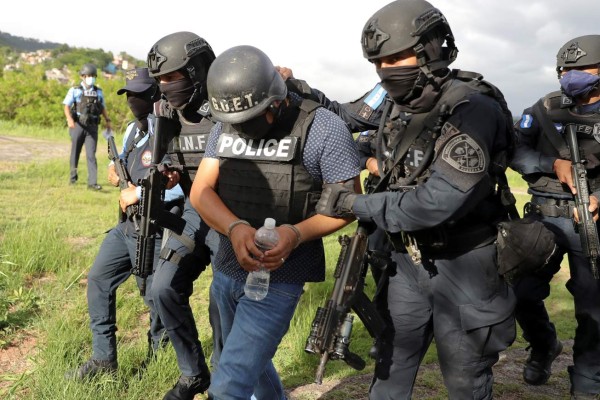 Un grupo de policías hondureños fue registrado este lunes al conducir a Carlos Miguel Cordón (c), quien es solicitado en extradición por Estados Unidos acusado de narcotráfico, en Tegucigalpa (Honduras). EFE/Gustavo Amador