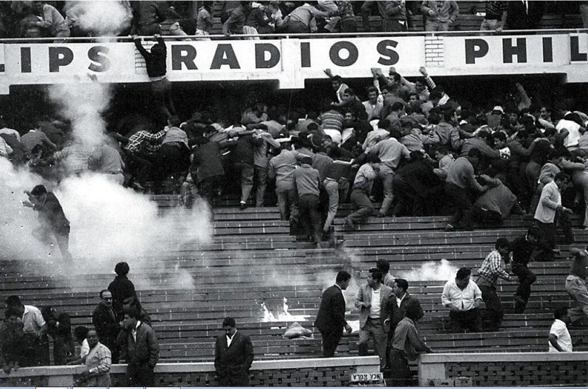 Aficionados huyendo de los gases lacrimógenos en el estadio Nacional de Lima el 24 de mayo de 1964.