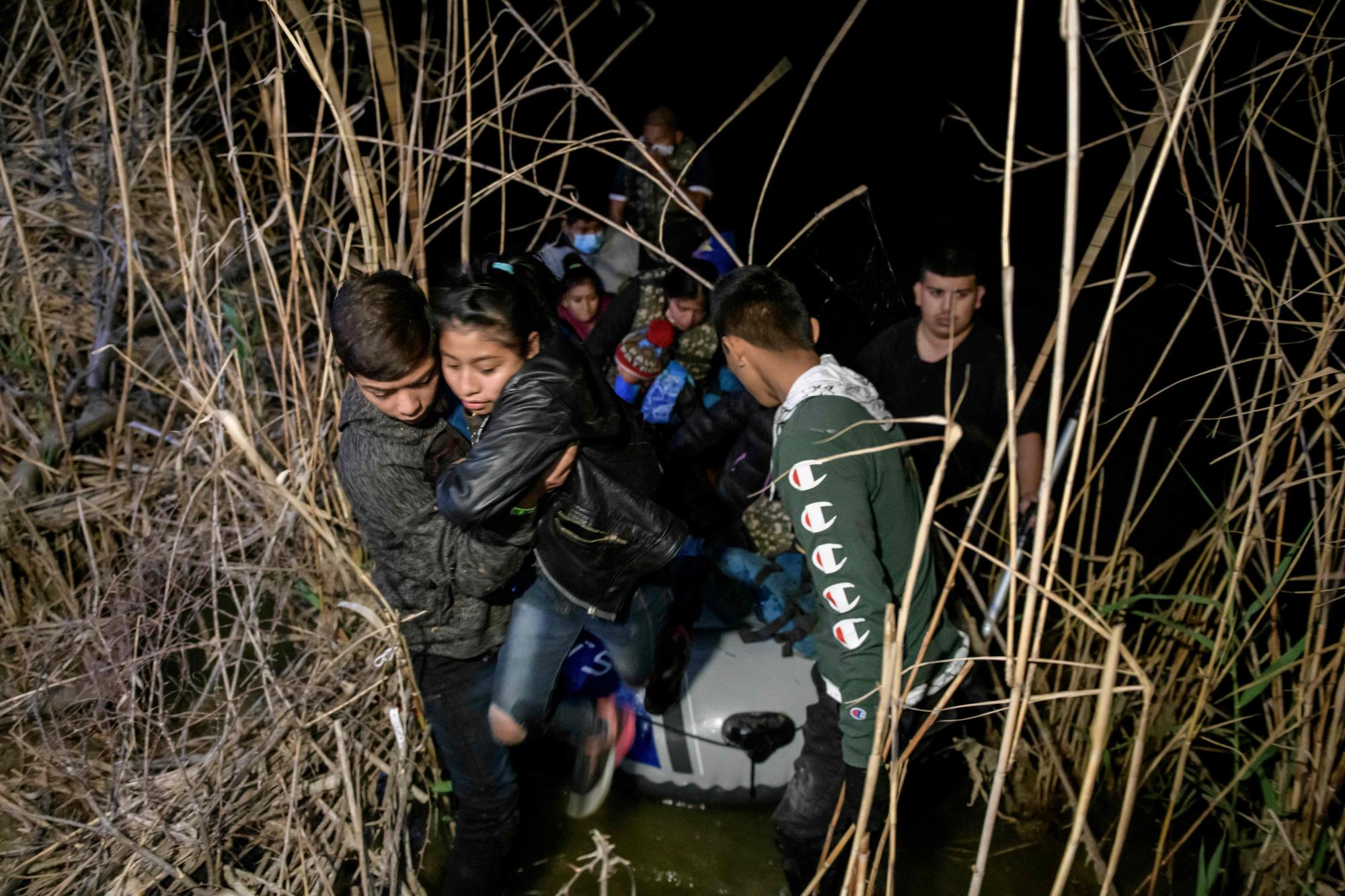 Un grupo de inmigrantes de Honduras y Guatemala que llegan ilegalmente desde México desembarcan de un bote inflable en el lado estadounidense del río Grande.