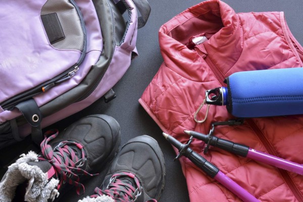 Hiking clothes for women and men, composed of boots, backpack, water bottle and walking sticks